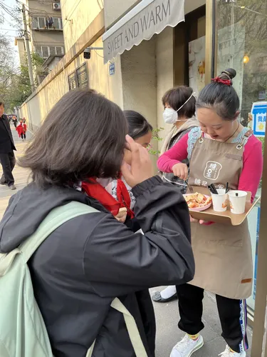 千妍在烘焙店门口请顾客试吃